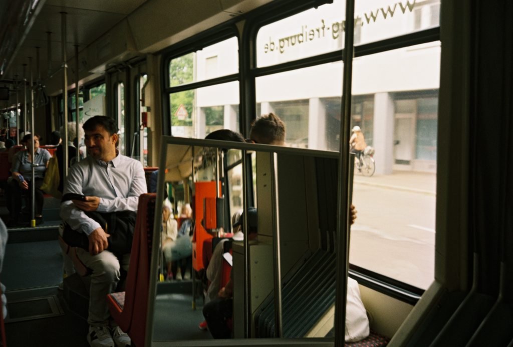 Large mirror inside a tram reflecting seats and passengers and visually displacing the interior space.